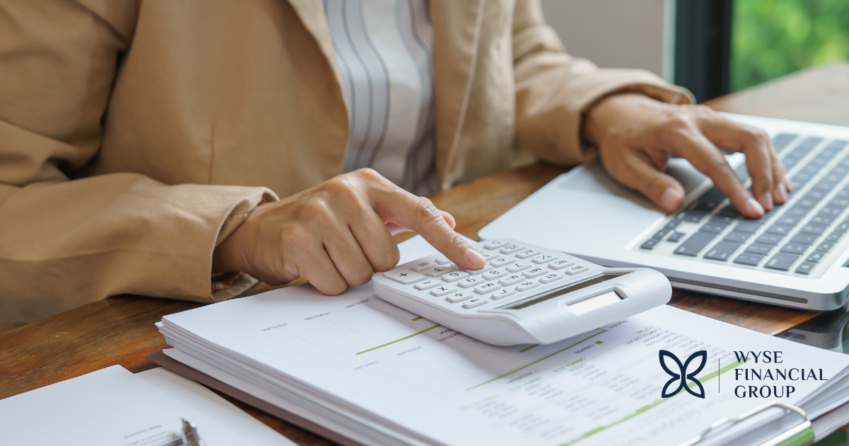 Woman typing on computer and calculator managing finances after losing a spouse